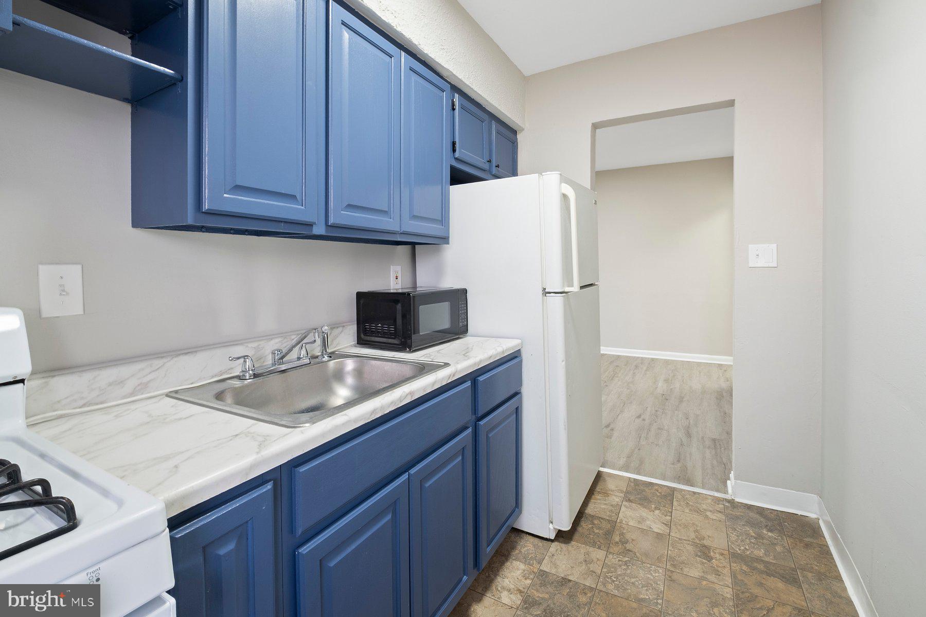 883 Bellevue Street Southeast, Unit 2 Washington, DC 20032 - Photo 26 of 37 a kitchen with a sink a refrigerator and cabinets