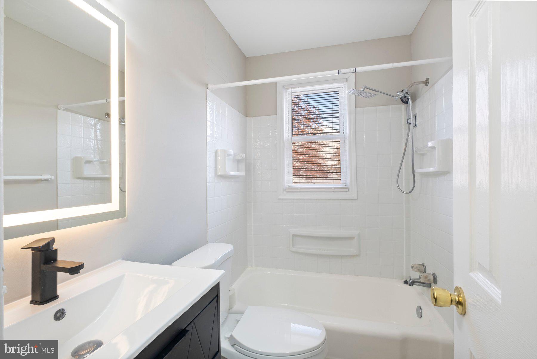 883 Bellevue Street Southeast, Unit 2 Washington, DC 20032 - Photo 27 of 37 a bathroom with a sink vanity tub and shower