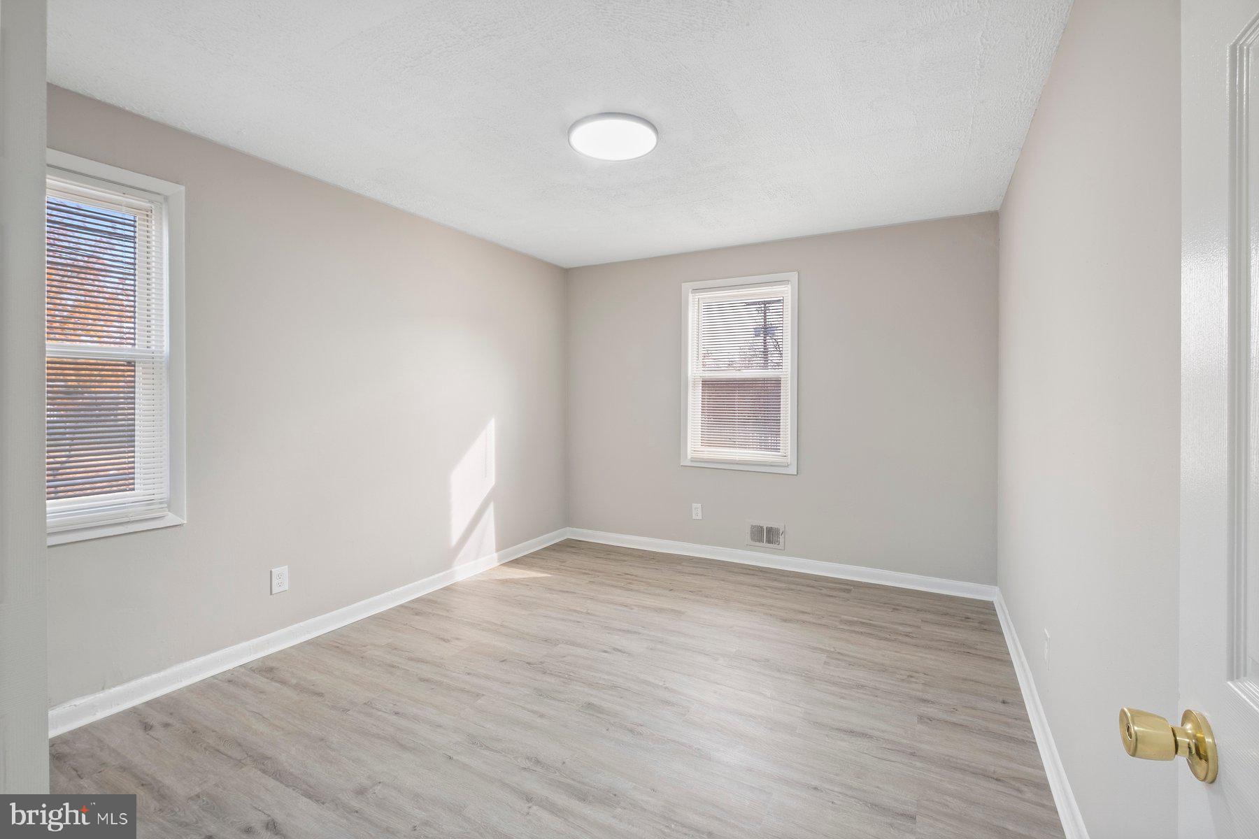883 Bellevue Street Southeast, Unit 2 Washington, DC 20032 - Photo 28 of 37 an empty room with wooden floor and windows