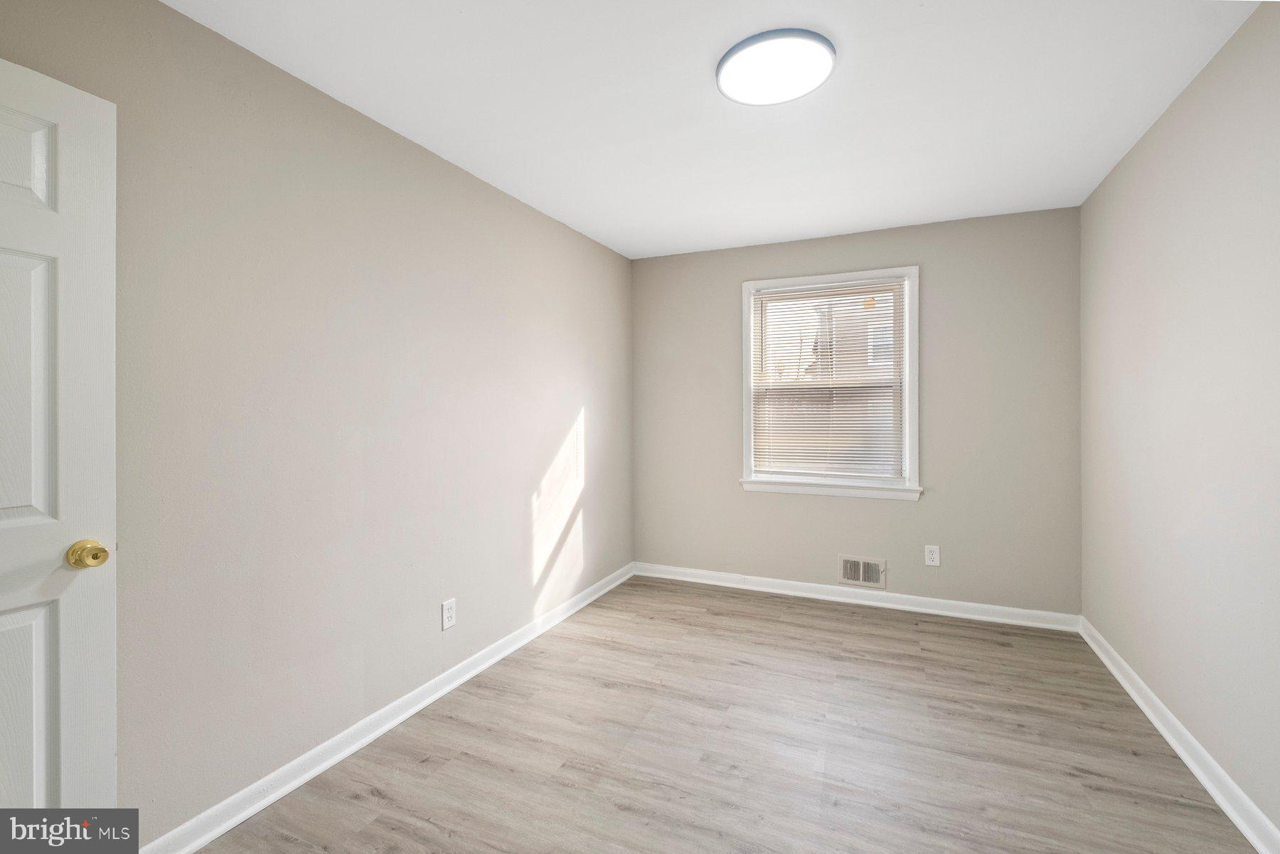 883 Bellevue Street Southeast, Unit 2 Washington, DC 20032 - Photo 31 of 37 an empty room with wooden floor and windows