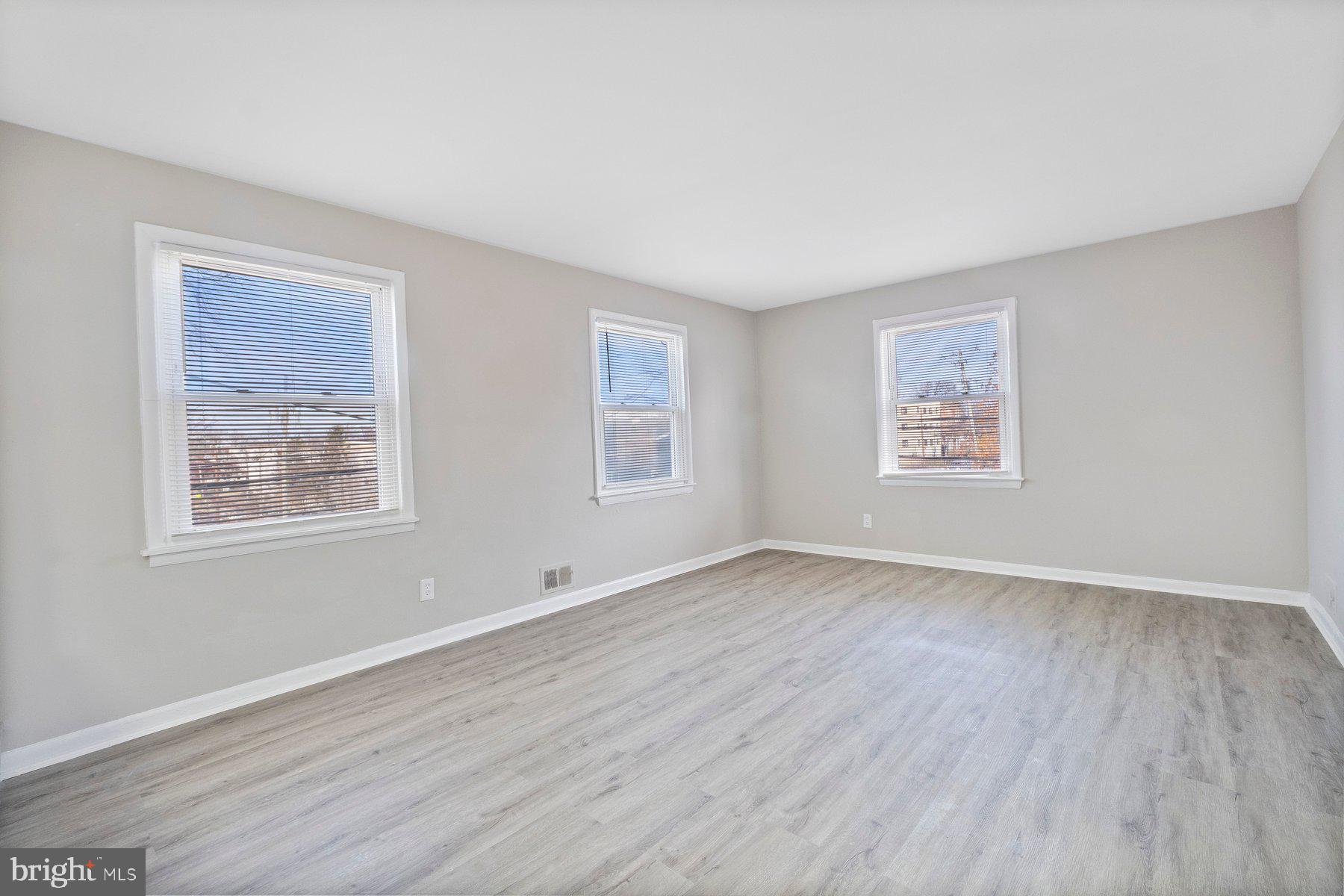 883 Bellevue Street Southeast, Unit 2 Washington, DC 20032 - Photo 4 of 37 a view of an empty room with wooden floor and a window
