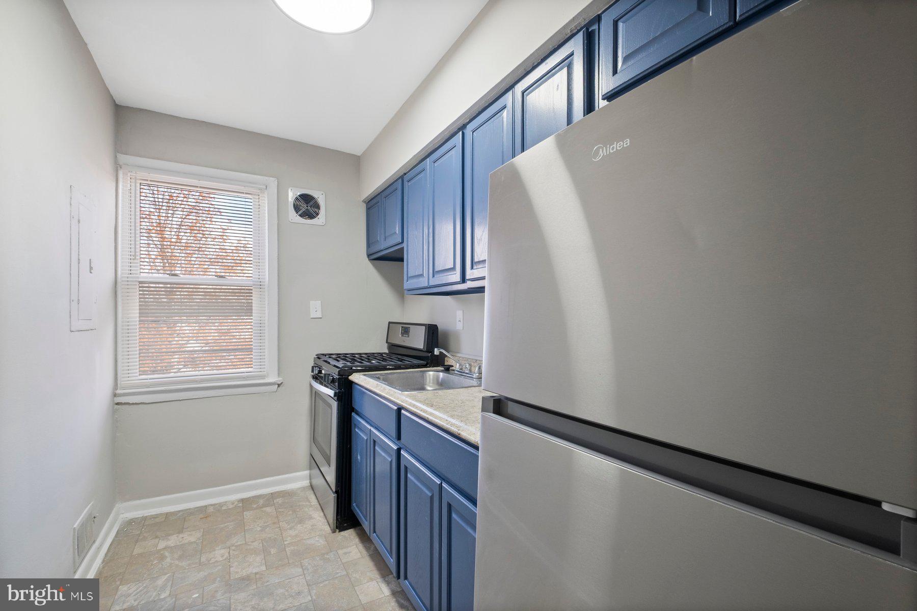 883 Bellevue Street Southeast, Unit 2 Washington, DC 20032 - Photo 10 of 37 a kitchen with granite countertop a sink a stove and refrigerator
