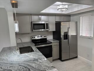 1704 University Lane, Unit 703 Cocoa, FL 32922 - Photo 1 of 18 a kitchen with a refrigerator stove and microwave