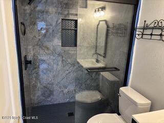 1704 University Lane, Unit 703 Cocoa, FL 32922 - Photo 8 of 18 a bathroom with a toilet sink and mirror