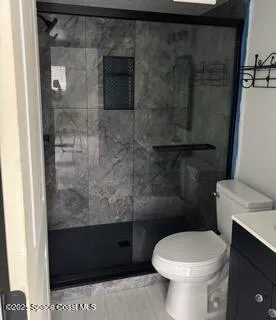 a bathroom with a toilet and a shower
