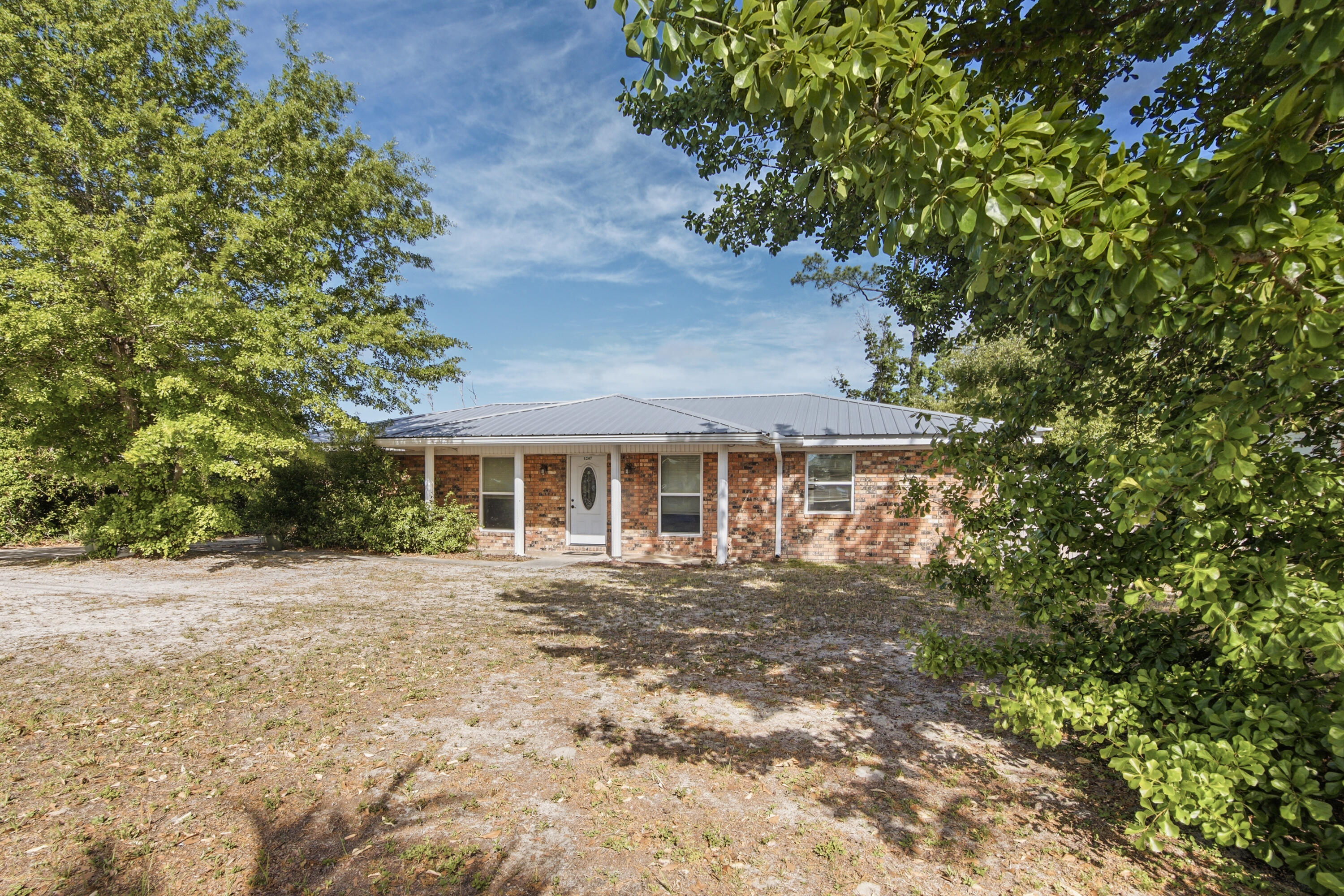1247 Amherst Road Panama City, FL 32405 - Photo 2 of 28 a front view of a house with a garden