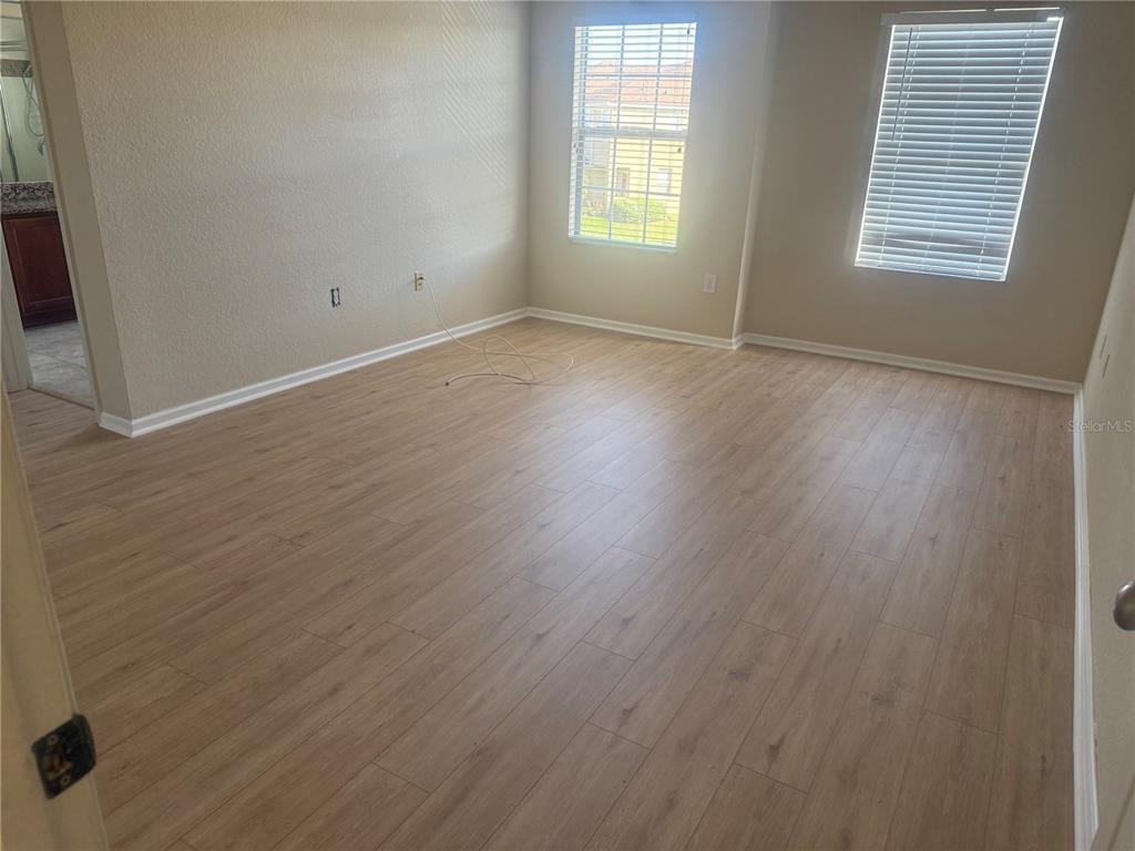 2992 Langdon Lane South Kissimmee, FL 34741 - Photo 18 of 39 an empty room with wooden floor and windows