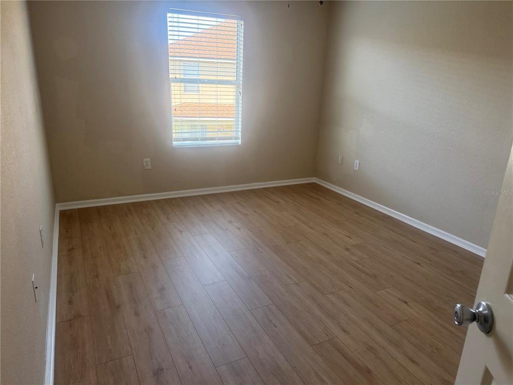 2992 Langdon Lane South Kissimmee, FL 34741 - Photo 24 of 39 an empty room with wooden floor and windows