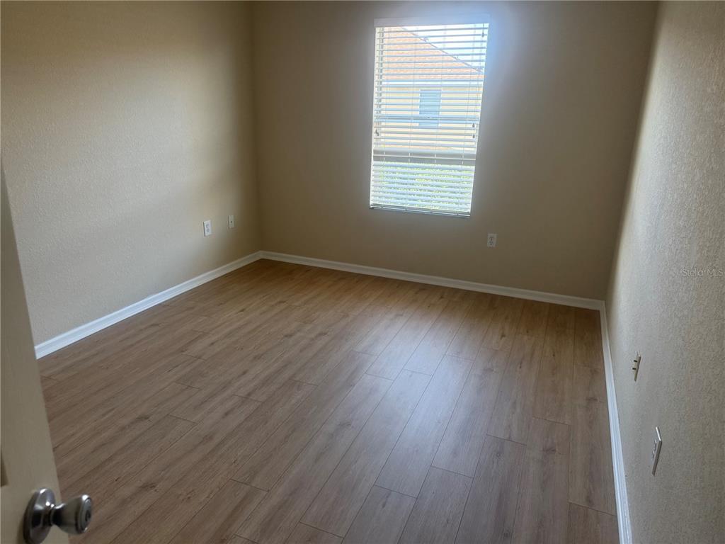 2992 Langdon Lane South Kissimmee, FL 34741 - Photo 25 of 39 an empty room with wooden floor and windows