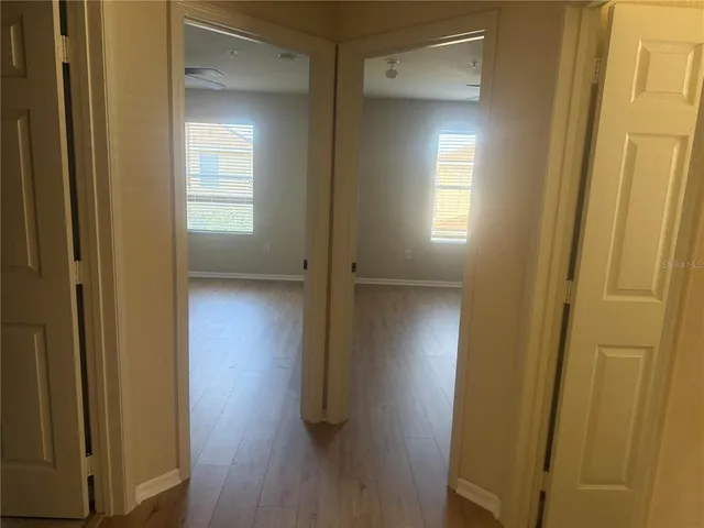 a view of a hallway with wooden floor