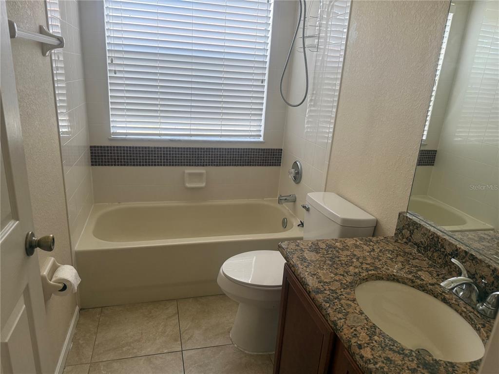 2992 Langdon Lane South Kissimmee, FL 34741 - Photo 38 of 39 a bathroom with a granite countertop sink a toilet and bathtub