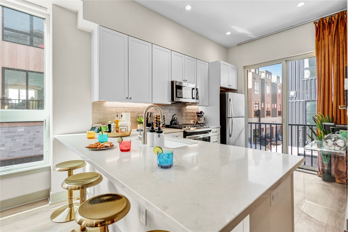 58 3rd Street, Unit D Silverthorne, CO 80498 - Photo 2 of 29 a kitchen with a sink a stove and chairs