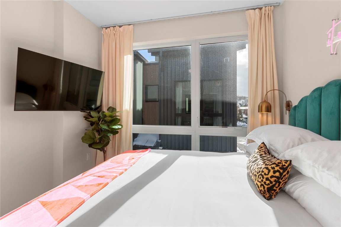 58 3rd Street, Unit D Silverthorne, CO 80498 - Photo 24 of 29 a bedroom with bed and flat screen tv