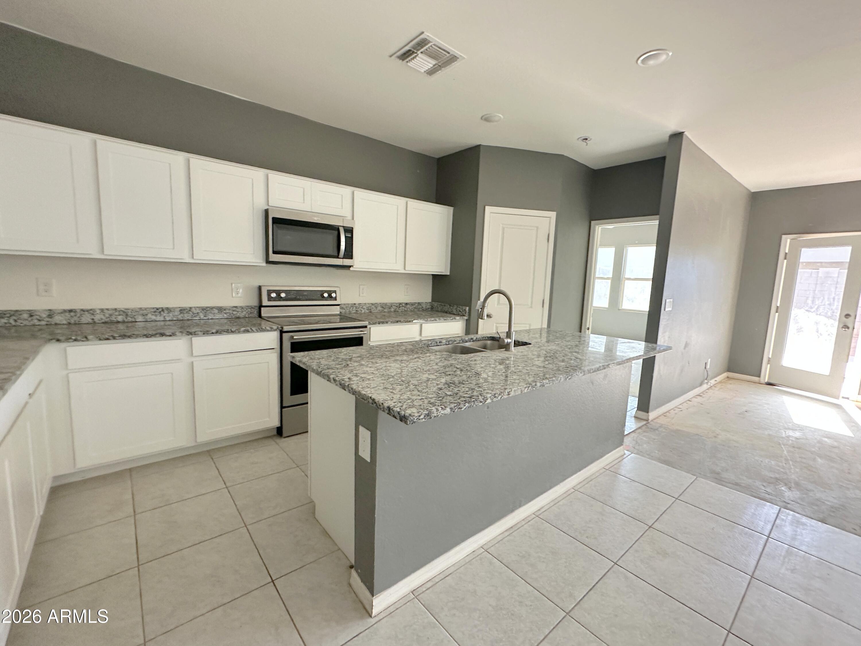 6085 East Athena Road Florence, AZ 85132 - Photo 8 of 21 a kitchen with stainless steel appliances granite countertop a sink and a stove