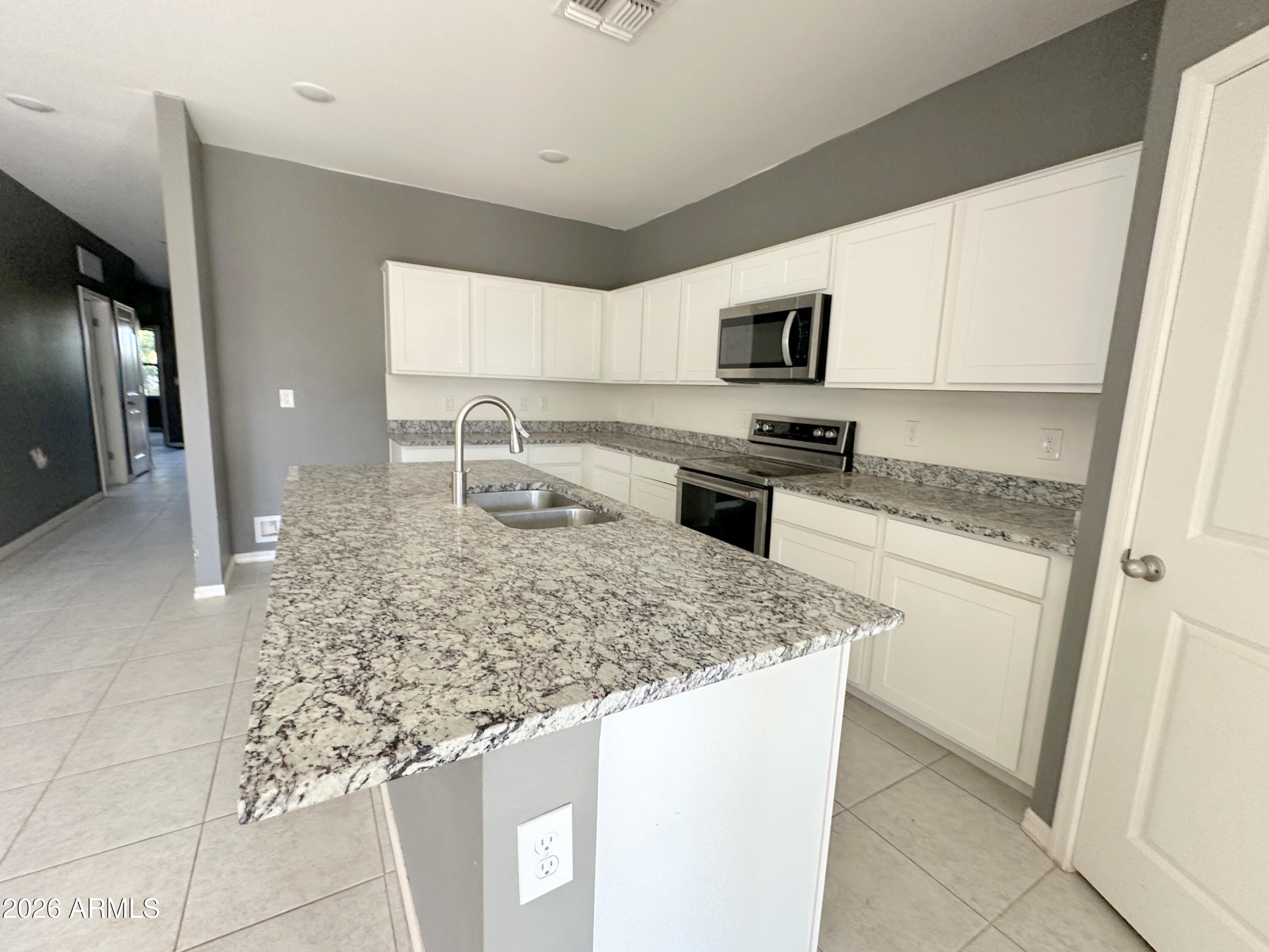 6085 East Athena Road Florence, AZ 85132 - Photo 9 of 21 a kitchen with stainless steel appliances granite countertop a sink stove and refrigerator