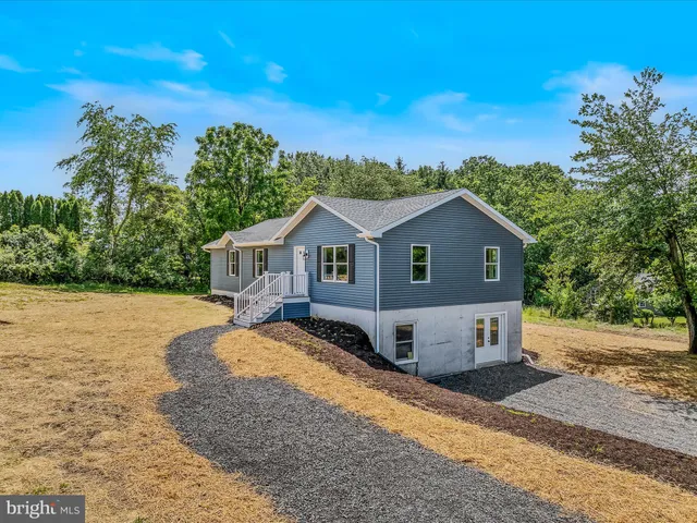 a front view of house with yard and trees in the background