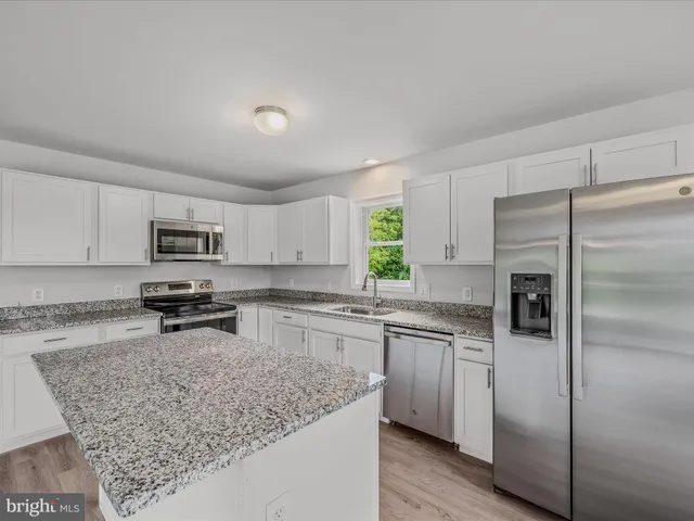 a kitchen with stainless steel appliances granite countertop a refrigerator stove microwave and sink