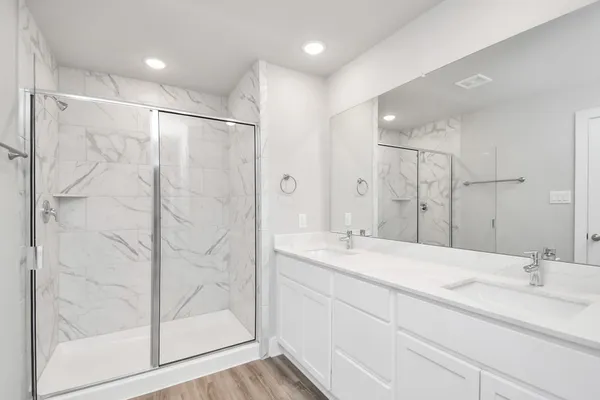 a bathroom with a double vanity sink mirror and shower