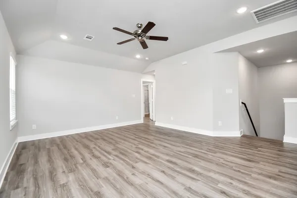 a view of empty room with wooden floor
