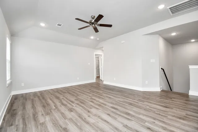 a view of empty room with wooden floor