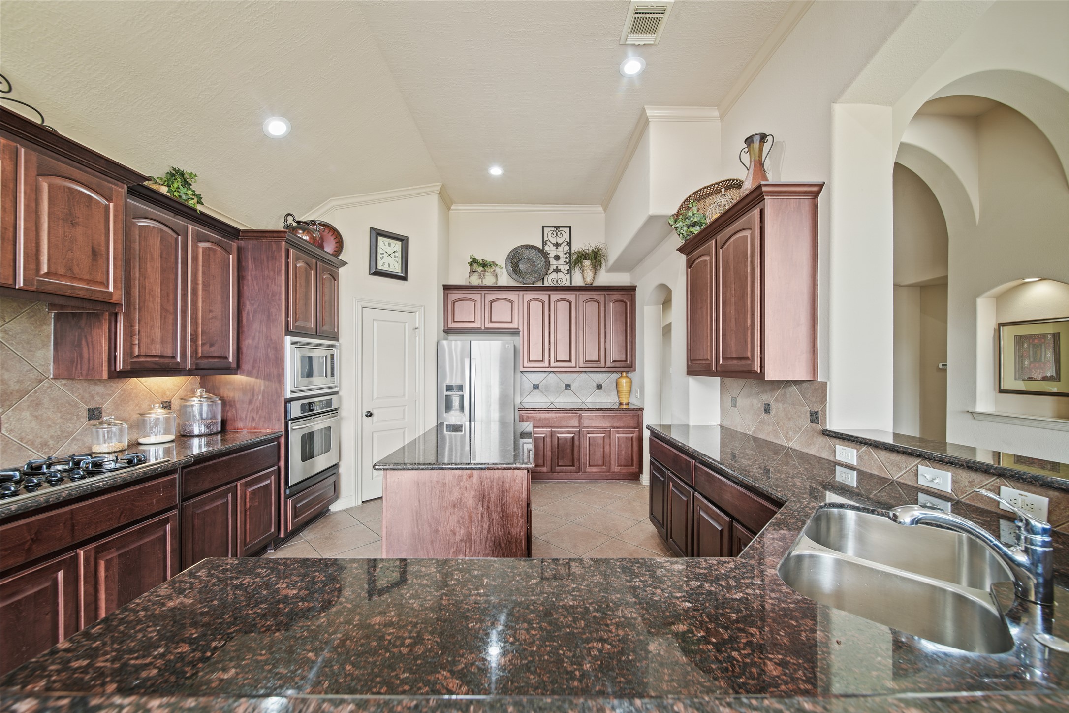 3414 Rue Orleans Missouri City, TX 77459 - Photo 21 of 46 a kitchen with wooden cabinets and sink