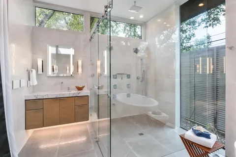 a bathroom with a sink a toilet and shower