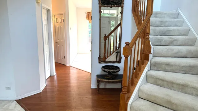 a view of staircase with lots of frames on wall and a window