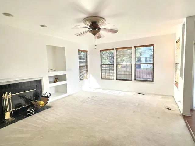 a view of an empty room with a fireplace and a window
