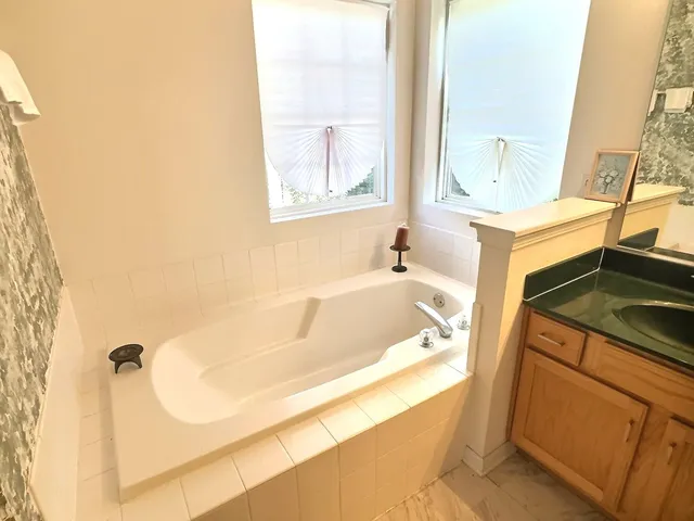 a bathroom with a tub sink and a mirror