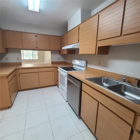 a kitchen with stainless steel appliances granite countertop a sink stove and cabinets