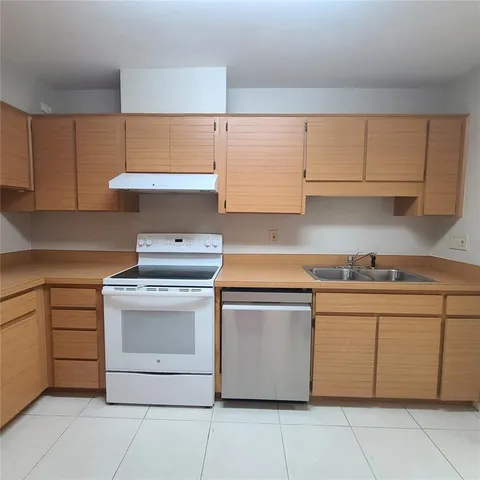 a kitchen with cabinets appliances and a sink
