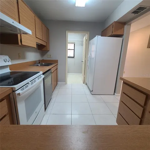 a kitchen with a refrigerator sink and cabinets