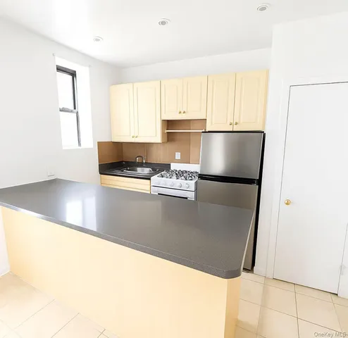 a kitchen with stainless steel appliances granite countertop a refrigerator a sink a stove a microwave and cabinets