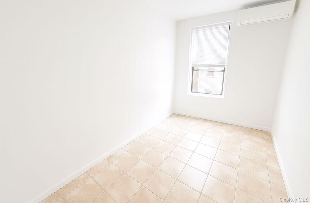 3440 Fulton Street, Unit 3F Brooklyn, NY 11208 - Photo 2 of 3 Unfurnished room with light tile patterned flooring and a wall unit AC