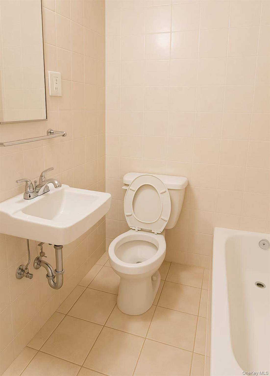 3440 Fulton Street, Unit 3F Brooklyn, NY 11208 - Photo 3 of 3 Bathroom featuring a bathtub, tile walls, and tile patterned floors