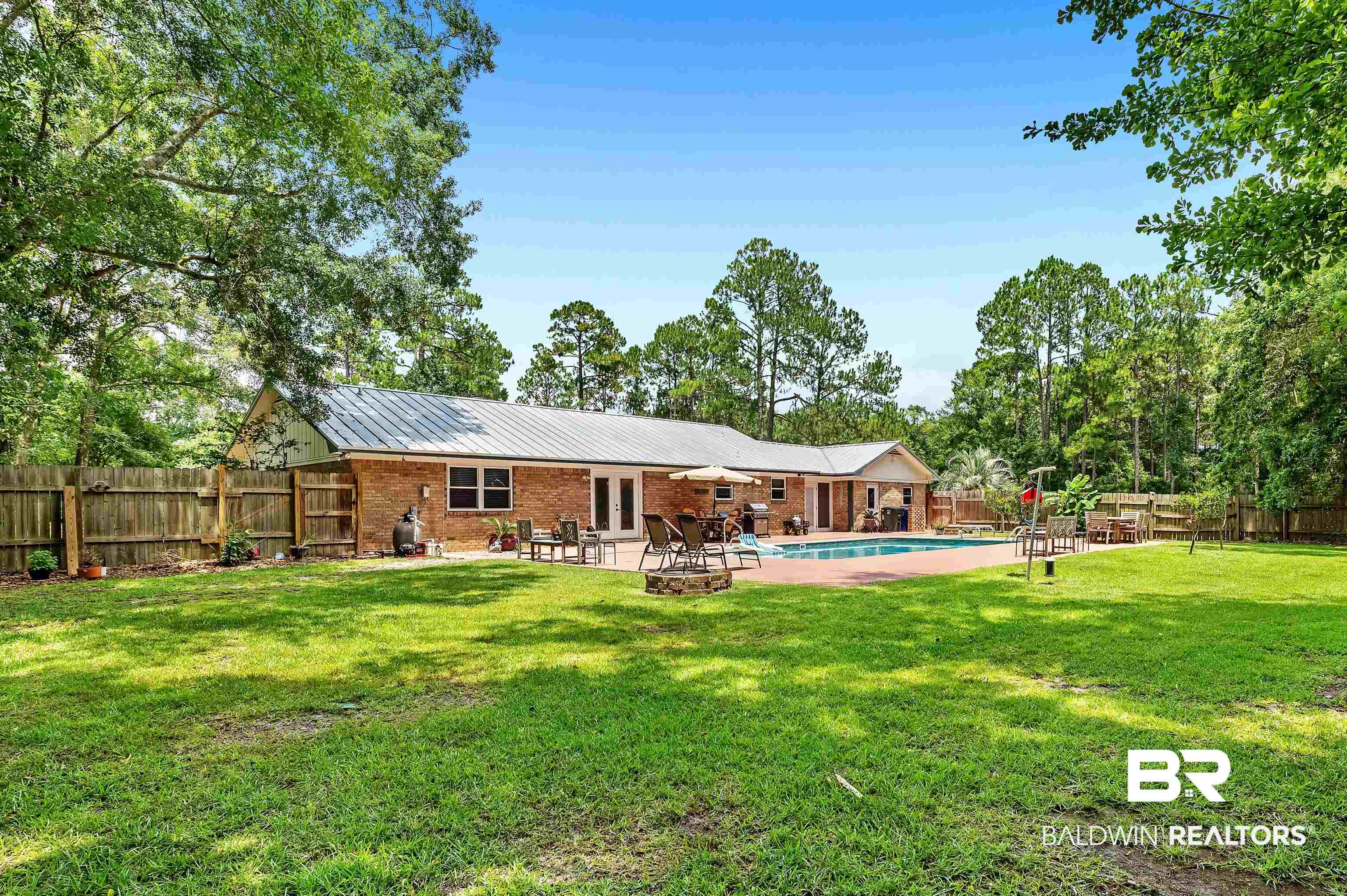 24551 Wolf Bay Drive Foley, AL 36535 - Photo 8 of 59 Rear view of house with a fenced backyard, a patio area, french doors, brick siding, and an outdoor fire pit