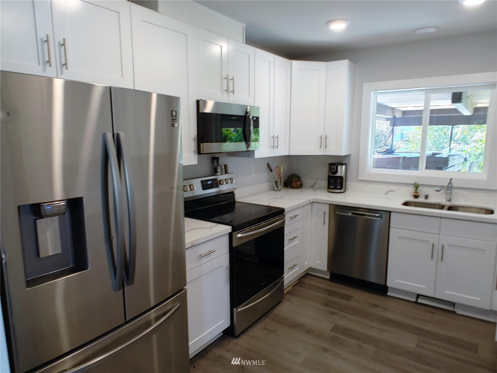 3506 Rockefeller Avenue Everett, WA 98201 - Photo 4 of 27 a kitchen with white cabinets stainless steel appliances and window