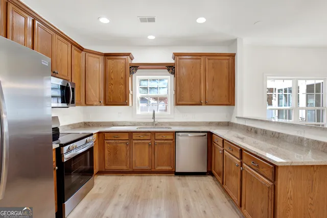 a kitchen with stainless steel appliances granite countertop a sink stove and refrigerator