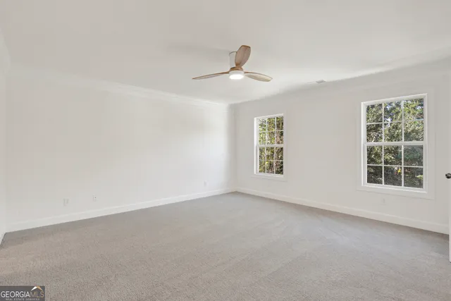 an empty room with a window and a ceiling fan