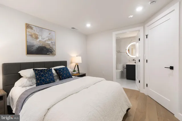 a bathroom with a sink a toilet a mirror and shower