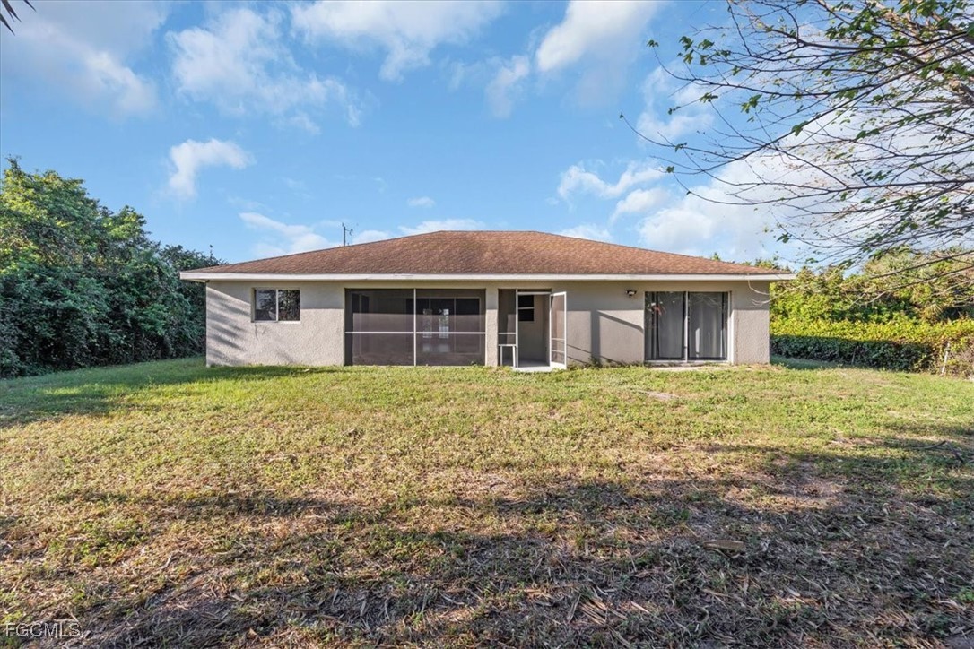 234 Pullman Street Lehigh Acres, FL 33974 - Photo 50 of 50 a front view of a house with a garden