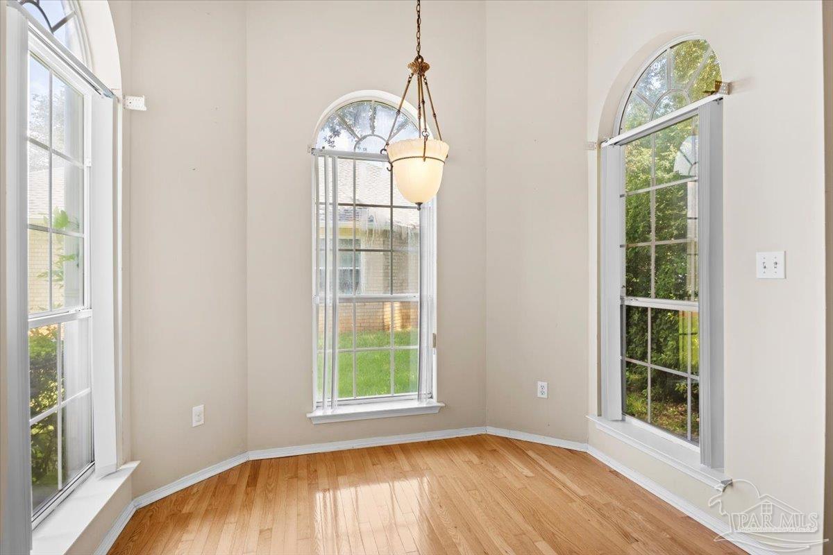 3485 Ashmore Lane Pace, FL 32571 - Photo 13 of 49 an empty room with wooden floor mirror and windows