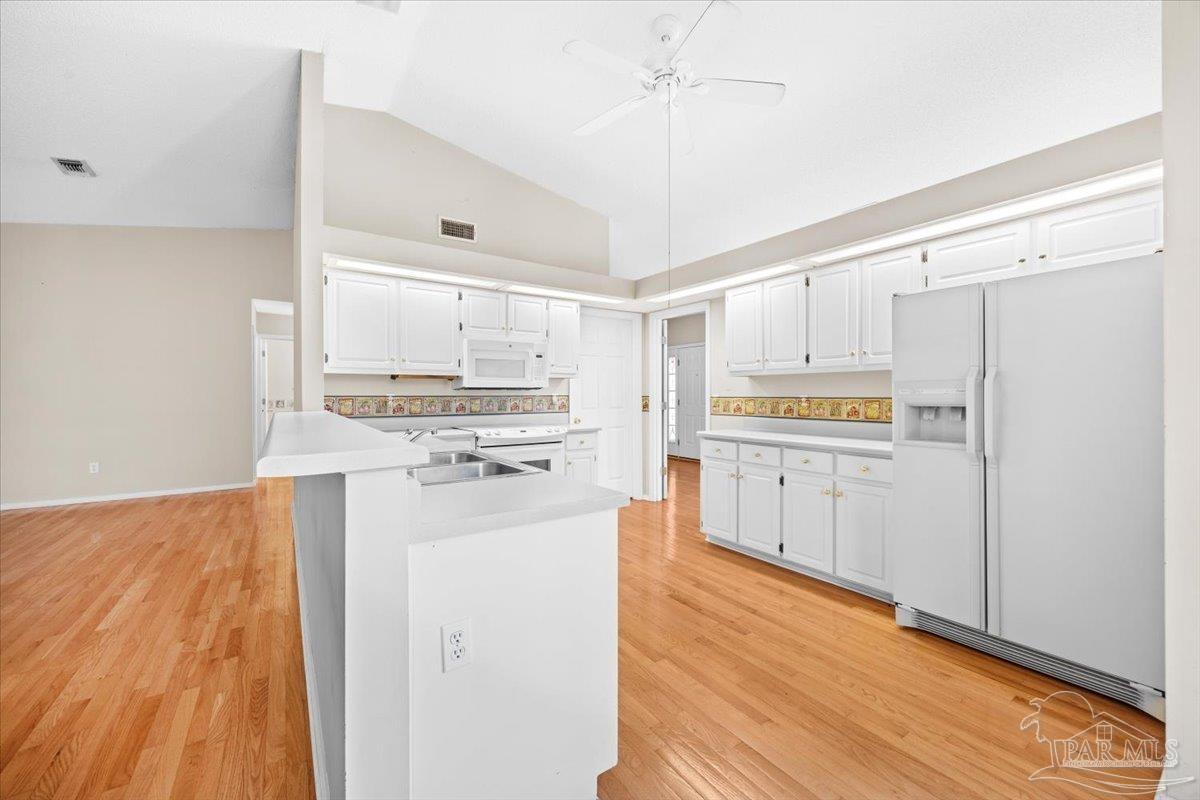 3485 Ashmore Lane Pace, FL 32571 - Photo 14 of 49 a kitchen with granite countertop white cabinets and white appliances