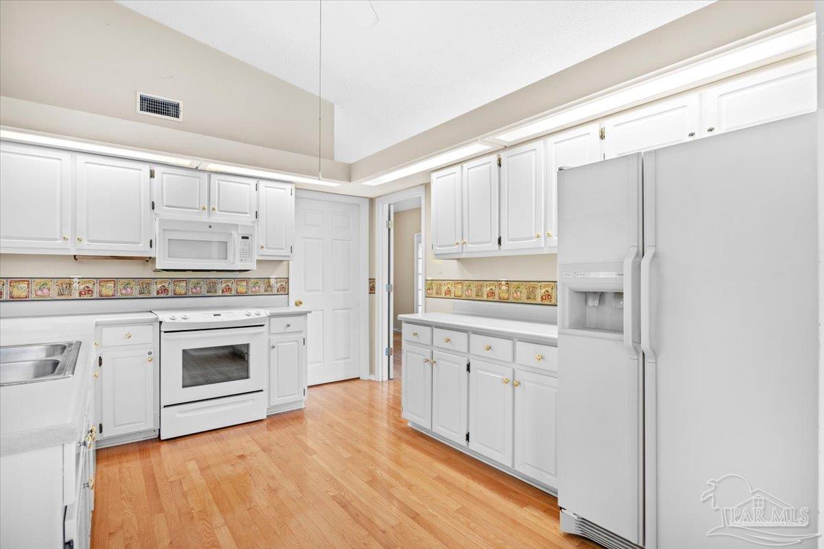 3485 Ashmore Lane Pace, FL 32571 - Photo 18 of 49 a kitchen with granite countertop white cabinets and refrigerator