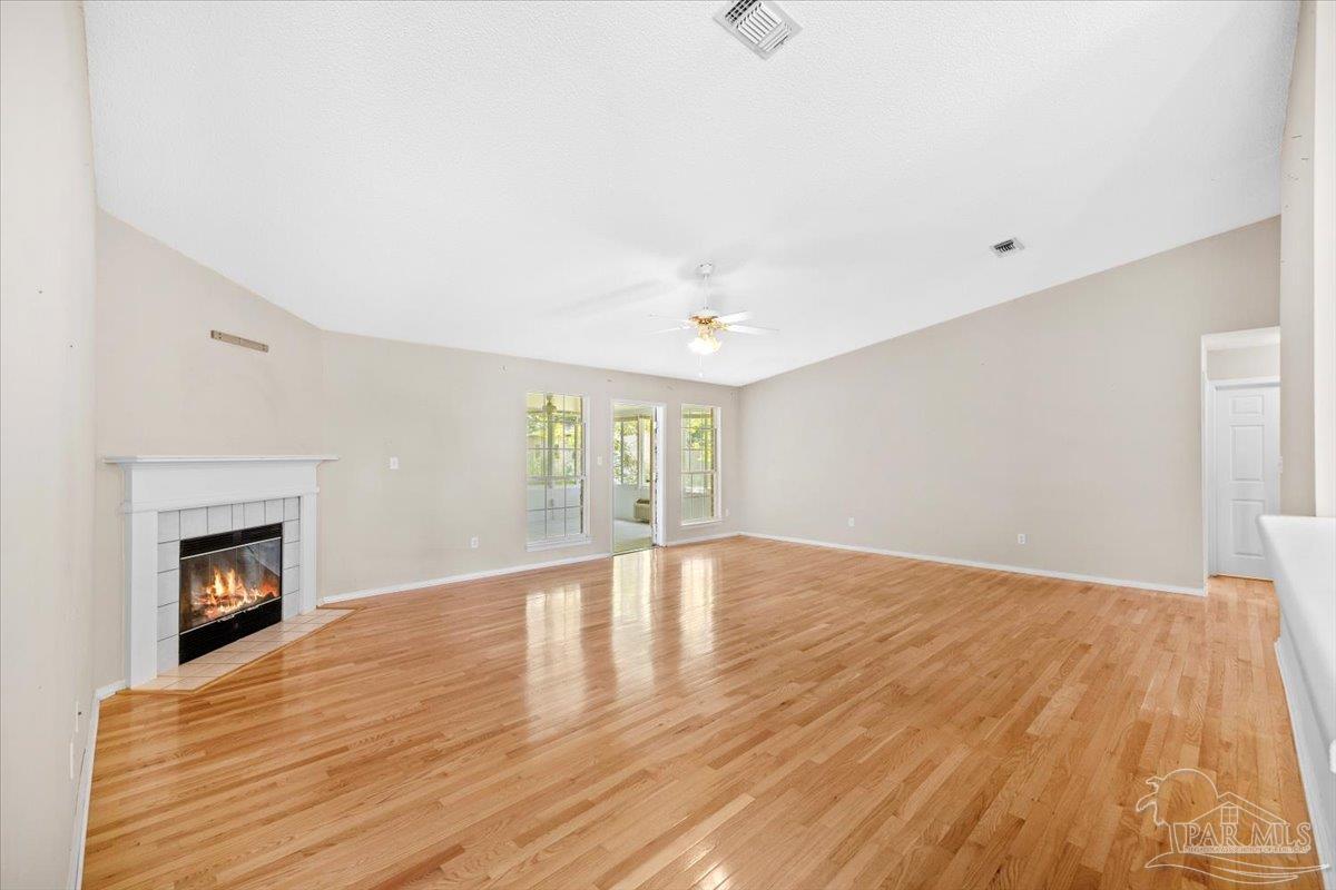 3485 Ashmore Lane Pace, FL 32571 - Photo 20 of 49 a view of empty room with wooden floor and fireplace