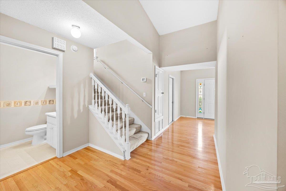 3485 Ashmore Lane Pace, FL 32571 - Photo 35 of 49 a view of a hallway with white walls and wooden floor