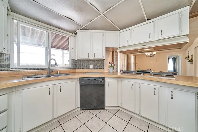 a kitchen with cabinets appliances a sink and a window