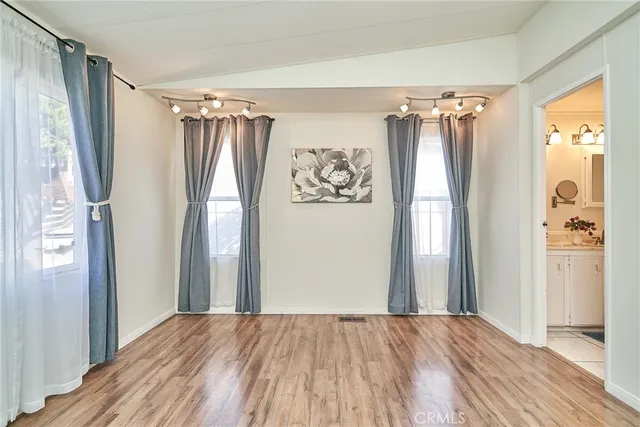 a view of walk in closet with wooden floor and a window