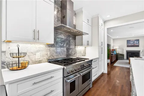 a kitchen with a stove and a white wooden cabinets