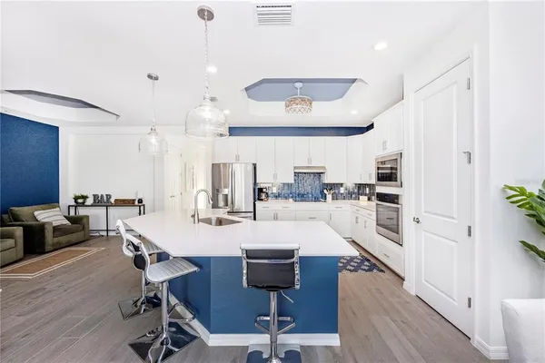 a living room with stainless steel appliances kitchen island granite countertop furniture and a dining table